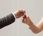 Real Estate Agent Giving Keys To Buyer Handover Concept. Close up cropped view of professional real estate agent wearing suit holding in hand and giving keys to young female buyer. Woman taking key of future new apartment